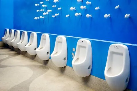 Urinal on blue wall Stock Photos