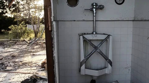 Urinal outside in torn up fire station Stock Footage 94695058