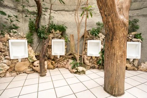 Urinal on the wall whit rocks Stock Photos