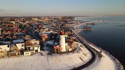 Urk Netherlands lighthouse during winter with snow covered coastline, Urk view Stock Footage 149921939