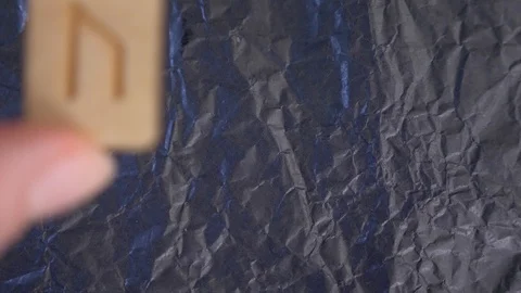 Uruz rune. close-up, hand puts the rune on the surface for divination. 4k, slow Video stock 87879622