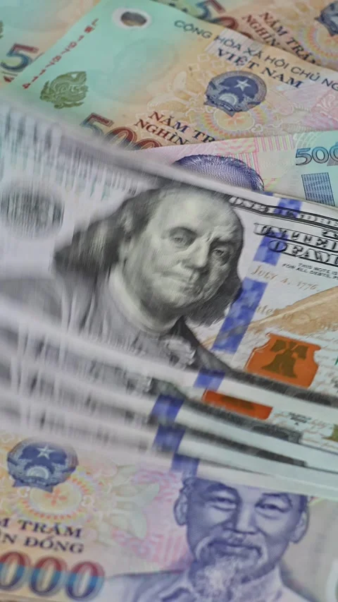 US 100 dollar banknotes falling on Vietnamese dong (VND) bills Video stock 333333149