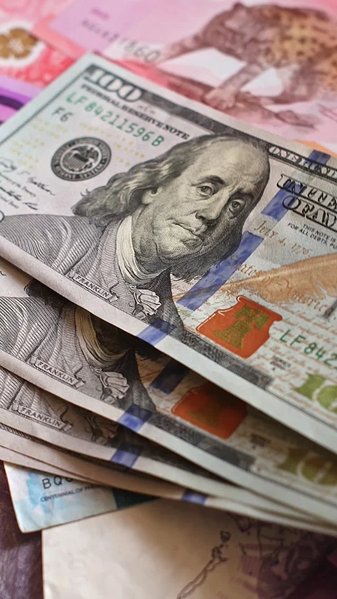 US 100 dollar notes (USD) are placed onto Philippine peso (PHP) bills Stock Footage 347515122