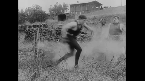 US - 1914 - in this silent comedy, a boxer chases his opponent on the street and Stock Footage 337953645