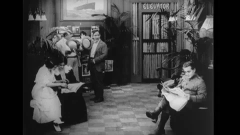 US - 1915 - in this silent comedy, two men see an officer reading a newspaper Stock Footage 277281942