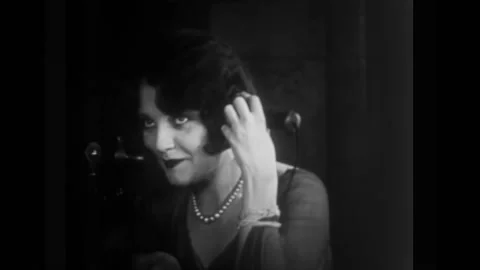 US - 1926 - in this silent comedy, a stranger in a phone booth speaks to a woman Stock Footage 327750601