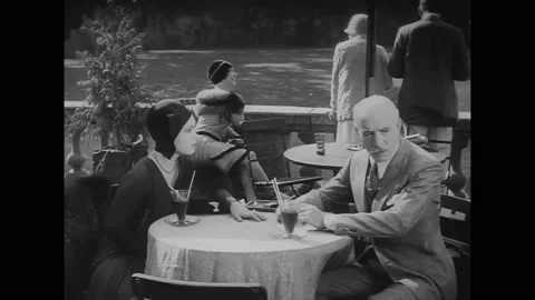 US - 1929 - in this comedy, a father has a drink with his daughter on a terrace. Stock Footage 323079671