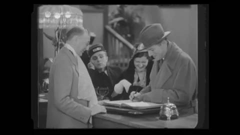 US - 1938 - in this parody, a couple is checking in at a hotel. When the man Stock Footage 254199835