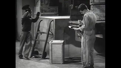 US - 1941 - A truck driver attempts to load a box of canned goods onto a truck. Stock Footage 340585936