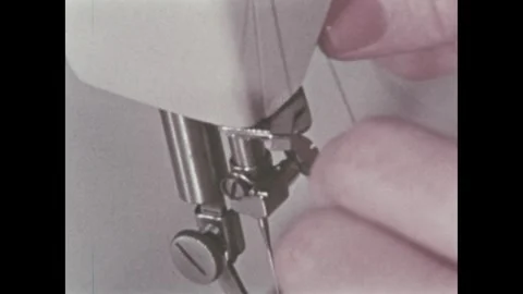 U.S. 1960s: a person's hand threading thread through the needle and presser Stock Footage 337173792