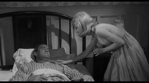 US - 1968 - in this drama, a bedridden man pretends to be asleep when his wife Stock Footage 337951550