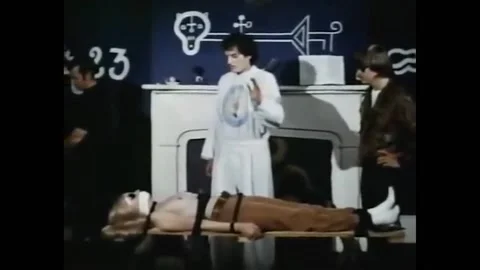 US - 1973 - in this sci-fi, in a ceremony, a man preaches to a gagged and bound Stock Footage 280182886