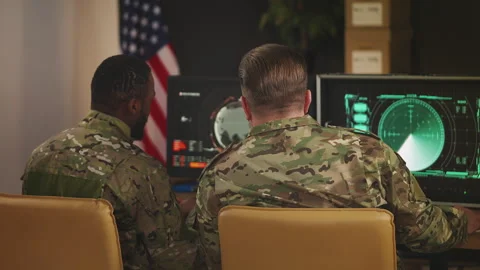 U.S. air defense operatives discussing surveillance data on computer screens Stock Footage 335538877