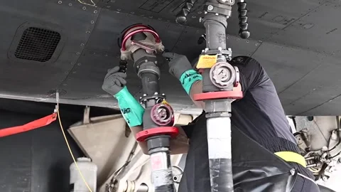 U.S. Air Force airman attaching fuel hose to B-1B Lancer for hot refueling Stock Footage 294335455