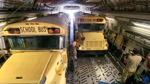 U.S. Air Force airman guiding school bus onto C-17 Globemaster aircraft Vidéo 213922832