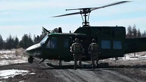 U.S. Air Force airmen approaching UH-1N Huey to board for static line jump Stock Footage 238910647