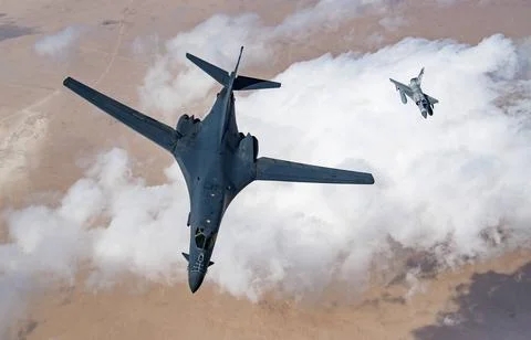 A U.S. Air Force B-1B Lancer bomber and a Qatari Mirage 2000 fly in format... Stock Photos