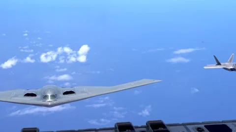 U.S. Air Force B-2 Spirit flying with F-22 Raptor aircraft Stock Footage 277571596