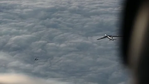 U.S. Air Force B-52 Stratofortress flying with a Saab JAS 39 Gripen above clouds Stock Footage 294522805