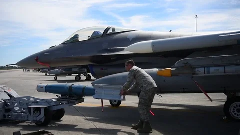 U.S. Air Force bomb loader positioning weapon for loading on F-16 Stock Footage 83306611