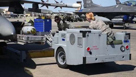 U.S. Air Force bomb loader with weapons being positioned under wing of F-16 Stock Footage 83309817