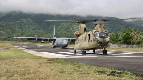 U.S. Air Force C-130 Hercules and U.S. Army CH-47 Chinook waiting on runway Stock Footage 274193421