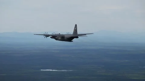 U.S. Air Force C-130 Hercules flying above Alaskan wilderness Stock Footage 277401185