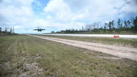 U.S. Air Force C-17 Globemaster aircraft touching down on dirt runway Video stock 277571519