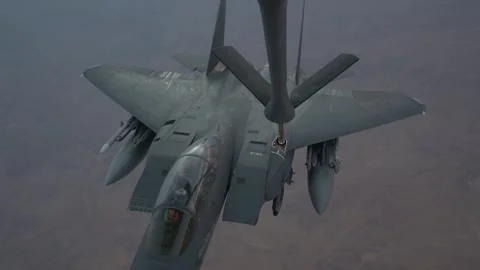 U.S. Air Force F-15E Strike Eagle conducts aerial refueling above desert Stock Footage 297066652
