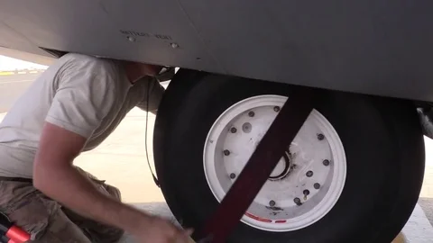 U.S. Air Force ground crew removing strap from landing gear of C-130 Hercules Stock Footage 85015479