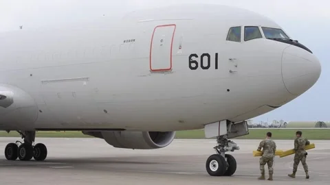 U.S. Air Force ground crew place chocks at landing gear of JASDF KC767J aircraft Stock Footage 236463470