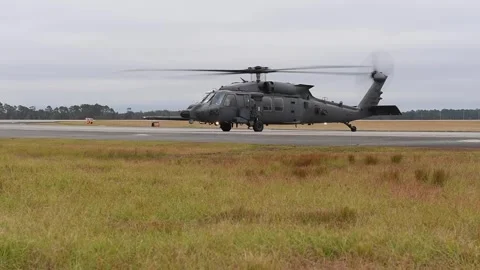 U.S. Air Force HH-60W Jolly Green helicopter ground-running on airstrip Stock Footage 255780537