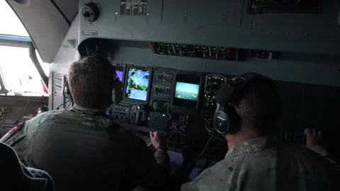 U.S. Air Force MC-130J Commando II flight engineers monitoring controls panels Stock Footage 258335711