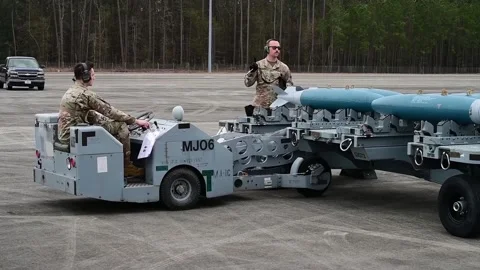 U.S. Air Force ordnanceman lifting weapons from trailer with bomb loader  Stock Footage 232681902
