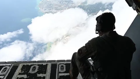 U.S. Air Force pararescueman looking out from MC-130J Commando II during flight Stock Footage 262530527