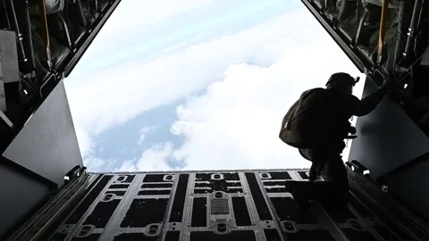 U.S. Air Force pararescueman looking out from MC-130J Commando II during flight Stock Footage 262530565
