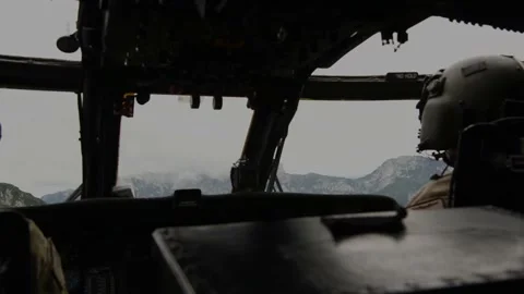 U.S. Air Force pilot flying HH-60 Pave Hawk helicopter through mountains Video stock 213581038