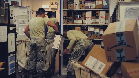 U.S. Air Force post office workers stacking packages on shelving Stock Footage 103586240