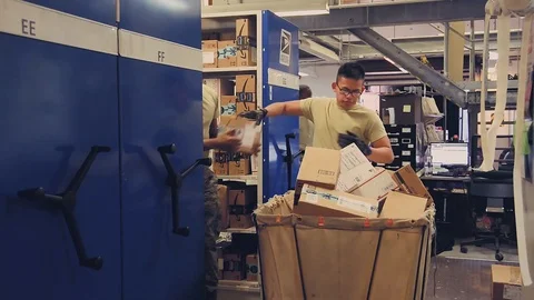 U.S. Air Force post office workers unloading boxes from mail trolley Stock Footage 103586254