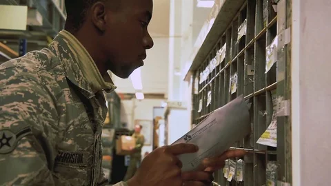 U.S. Air Force post office worker sorting mail into pigeon holes Stock Footage 103586267