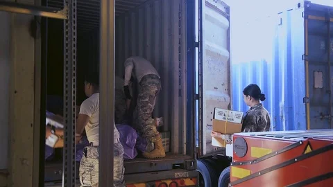 U.S. Air Force post office workers unloading packages from delivery truck Vídeos de archivo 103586298