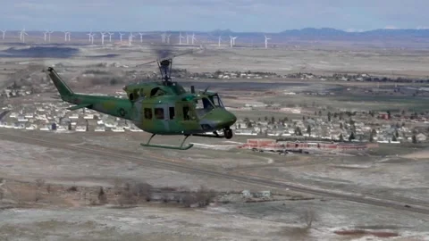 U.S. Air Force UH-1N Huey flying over landscape dusted with snow Stock Footage 260223154