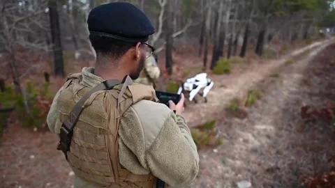 U.S. Airman operating semi-autonomous Robot Dog while patrolling woodland track Видео 234407788