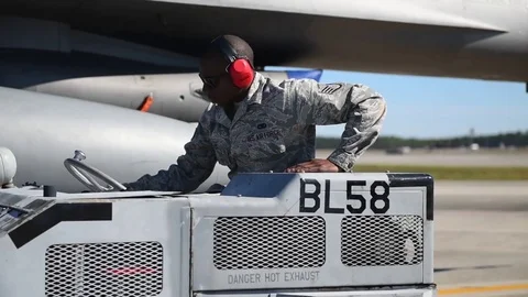 U.S. Airman reversing bomb loader during building and loading program with F-16 Stock Footage 83309536