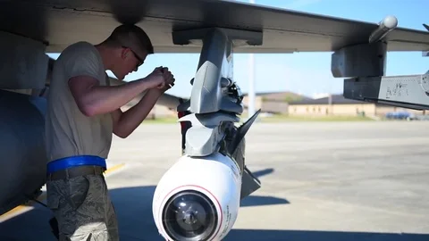 U.S. Airman securing weaponry onto F-16 during building and loading program Stock Footage 83307193