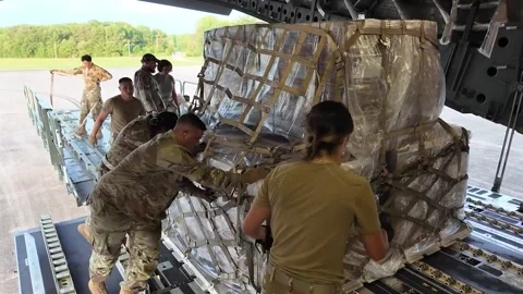 U.S. Airmen loading pallet of cargo from aircraft loader onto C-17 Globemaster Stock Footage 281932162