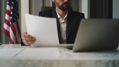 U.S. ambassador working with documents in embassy providing consular services Stock Footage 327784553