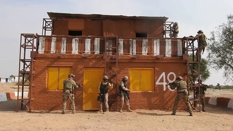 U.S. and Indian special forces soldiers throw grenades into building  Video stock 104655328
