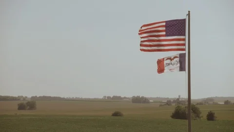 U.S. and Iowa flags waving in the wind in slow motion Stock Footage