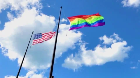 U.S. and Rainbow Flags Fly Above Navy Pier During Gay Pride Month Celebration Stock Footage 277286342